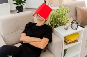 Person lying on the couch with book on his face